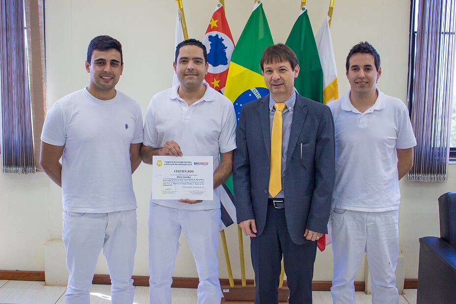 Foto 1: Entrega do certificado de Mérito Científico aos autores do Trabalho: Comparação do suporte ósseo periodontal em ratos machos e fêmeas velhos, do curso de Odontologia.